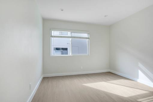 A room with a window and wooden flooring.