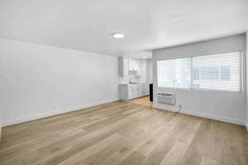 A room with wooden flooring and white walls.