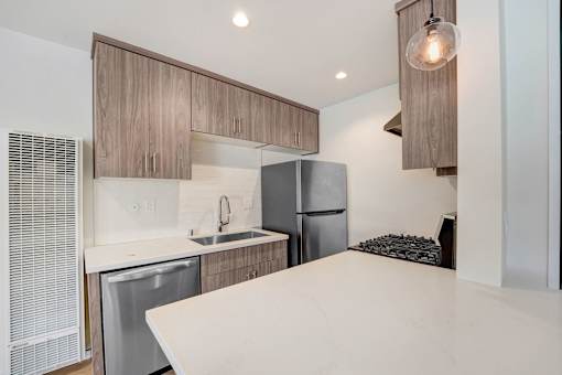 A modern kitchen with a dishwasher and a refrigerator.