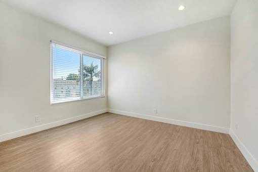 A room with a window and wooden flooring.