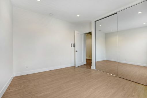 A room with a wooden floor and a mirror on the wall.