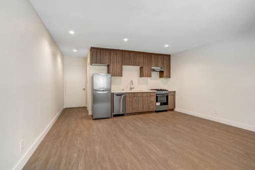 A kitchen area with a refrigerator, oven, and sink.