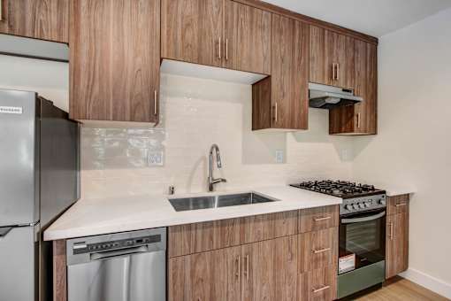 A kitchen with wooden cabinets and a stainless steel refrigerator.