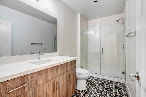 A bathroom with a sink, toilet, and shower.