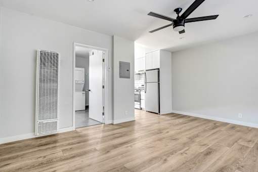 A room with a ceiling fan and wooden flooring.