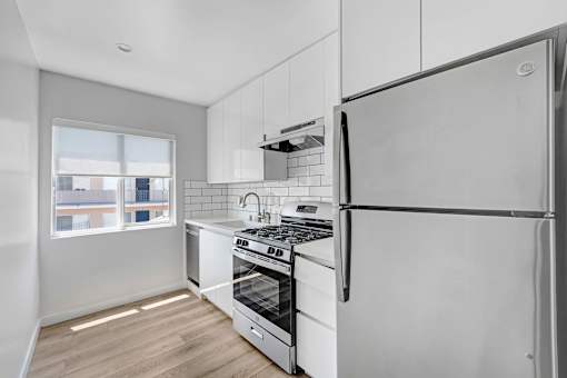 A modern kitchen with a refrigerator, stove, and oven.