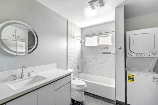 A white bathroom with a toilet, sink, and bathtub.