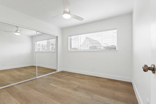 A room with a wooden floor and a ceiling fan.