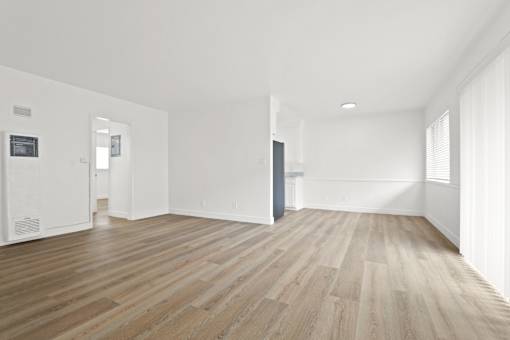 A room with wooden flooring and white walls.