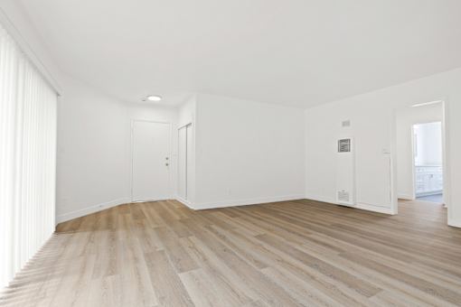 A room with wooden flooring and white walls.