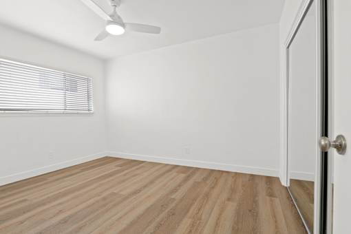 A room with a wooden floor and a ceiling fan.