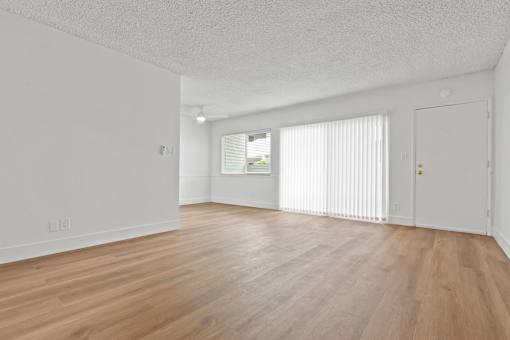 A room with wooden flooring and white walls.