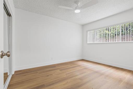 A room with a wooden floor and a ceiling fan.