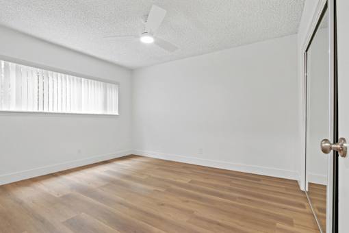 A room with a wooden floor and a ceiling fan.