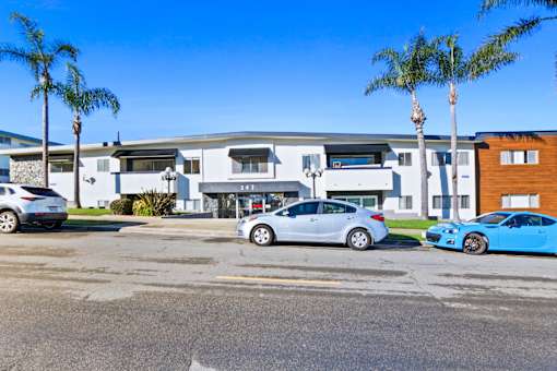 A parking lot with cars and a building in the background.