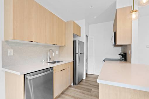 A kitchen with wooden cabinets and a stainless steel dishwasher.