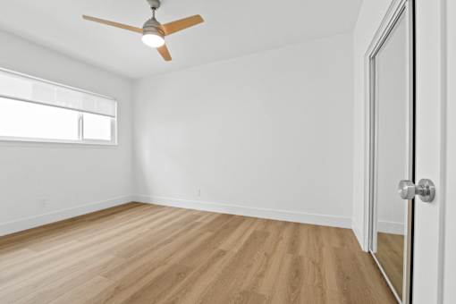 A room with a ceiling fan and a door.