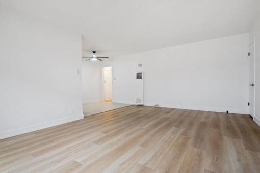 A room with wooden flooring and a ceiling fan.