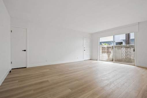 A room with wooden flooring and white walls.