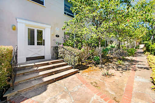 A house with a white door and a small garden in front.