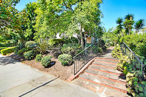 A garden with a staircase and a metal railing.
