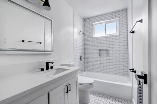 a white bathroom with a sink and a toilet and a shower