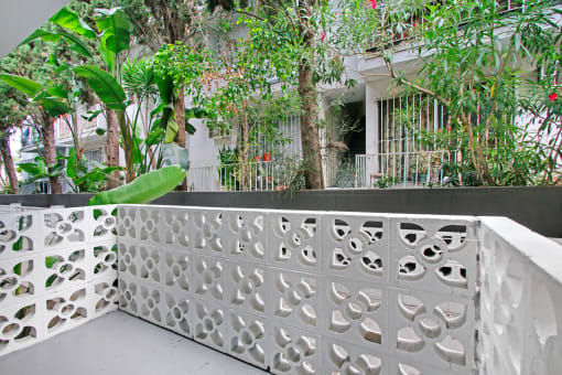 a balcony with a white fence and plants