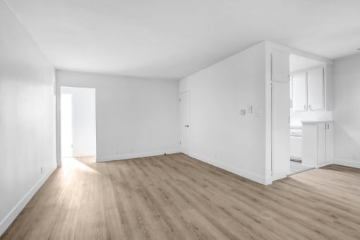 an empty living room with white walls and wooden floors