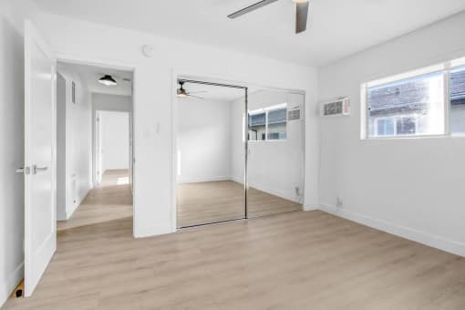 an empty room with white walls and a sliding glass door