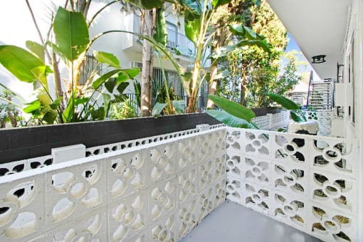 a balcony with a white fence and plants