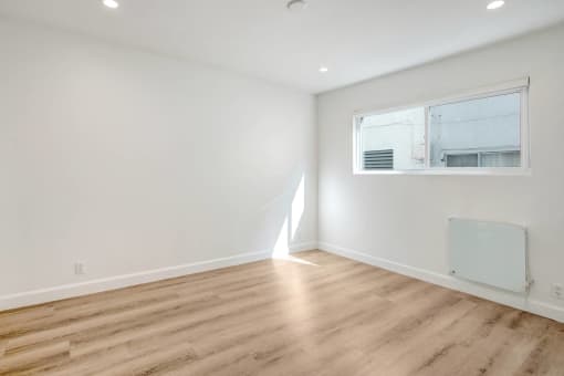 a living room with white walls and a window