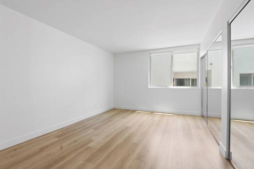 A room with wooden flooring and white walls.
