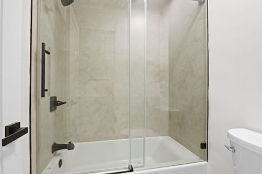 A white bathroom with a glass shower door.