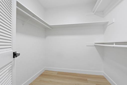 A white room with a black door handle and wooden flooring.
