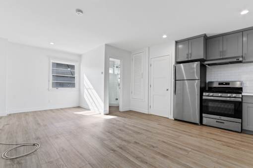 A kitchen with a refrigerator, oven, and microwave.
