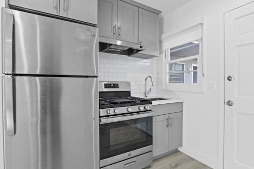 A modern kitchen with a stainless steel refrigerator and oven.