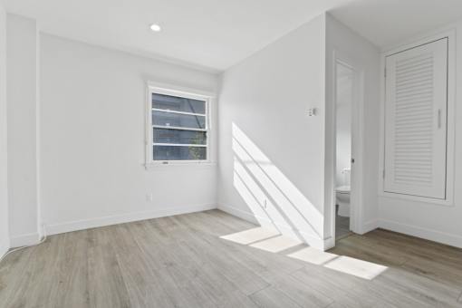 A room with a window and wooden flooring.