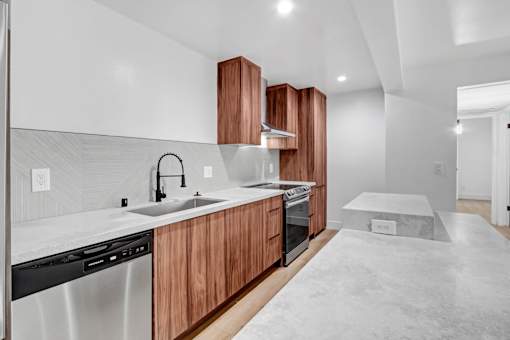 A modern kitchen with wooden cabinets and a marble countertop.