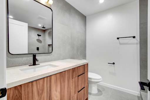 A modern bathroom with a white sink and a white toilet.