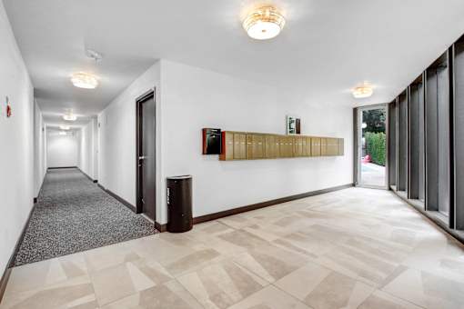 A long hallway with a checkered floor and a wall with a picture on it.