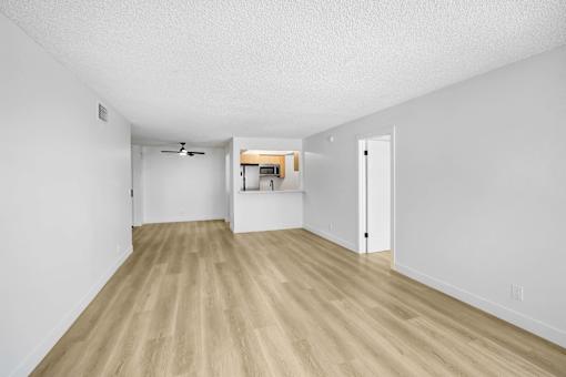 A room with wooden flooring and white walls.