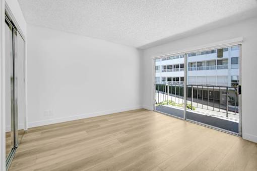 A room with a sliding glass door leading to a balcony.