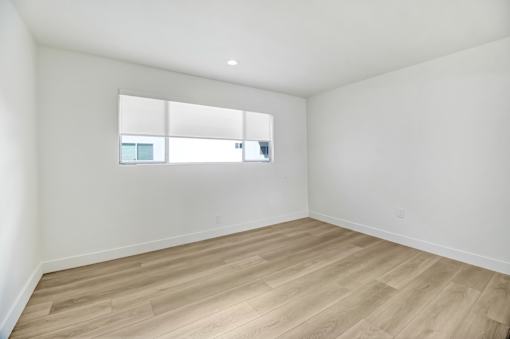 A room with wooden flooring and a window.