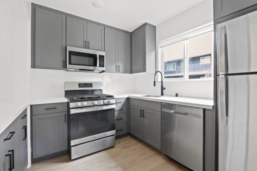 a kitchen with stainless steel appliances and gray cabinets