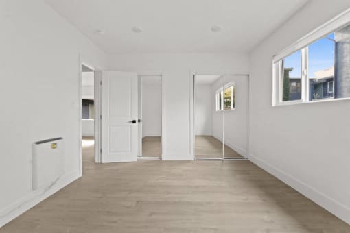 a living room with white walls and white doors and a wood floor