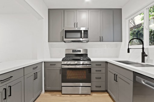 a modern kitchen with stainless steel appliances and gray cabinets