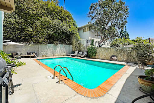 A small pool with a concrete floor and a wall surrounding it.
