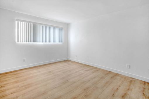 an empty room with white walls and a window