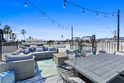 A patio with a table, chairs, and a pool.