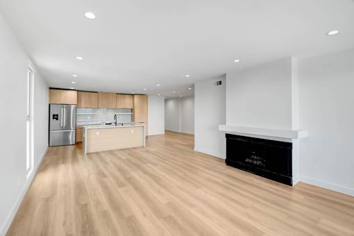 A modern kitchen with a wooden floor and white walls.